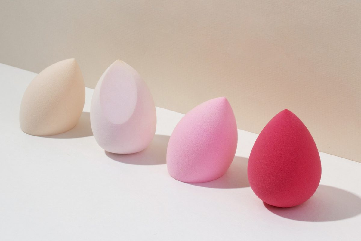 Row of beauty sponges in nude, blush and pink on a white table