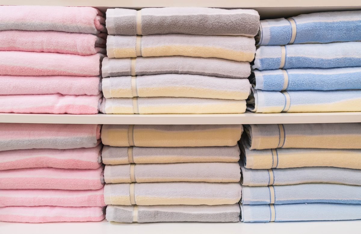 Stacks of folded pastel towels on shelves