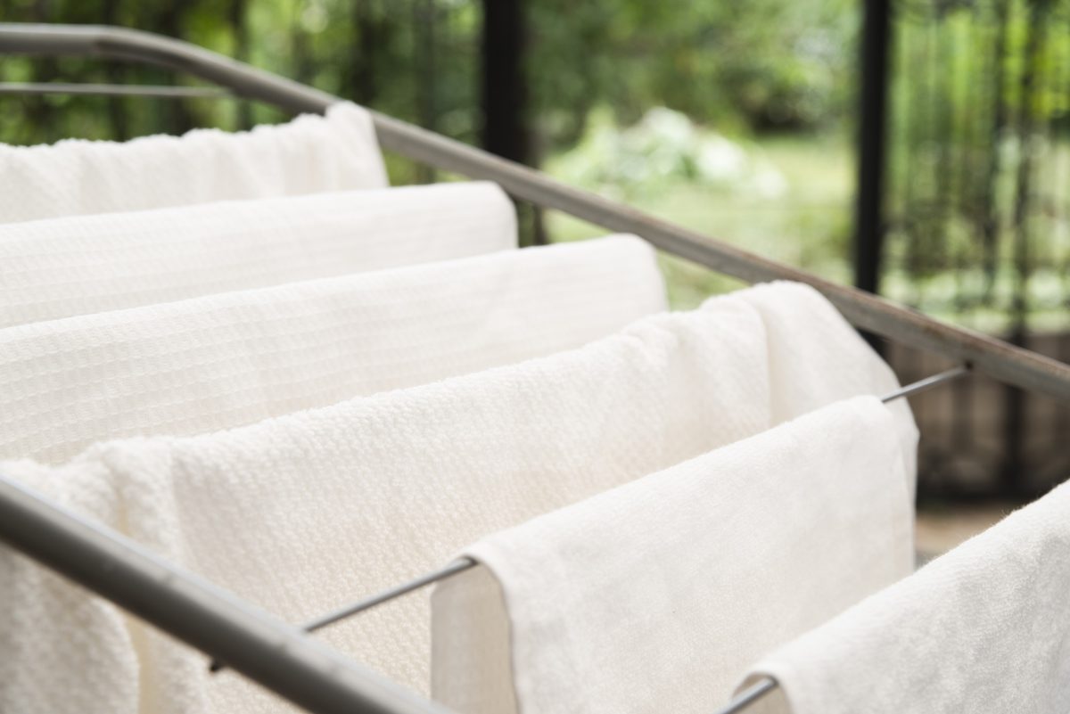 White towels drying on a clothes rack in soft daylight