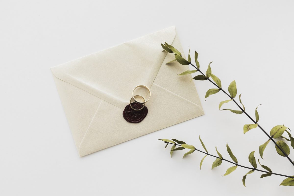 Cream envelope sealed with a dark red wax seal beside a green branch