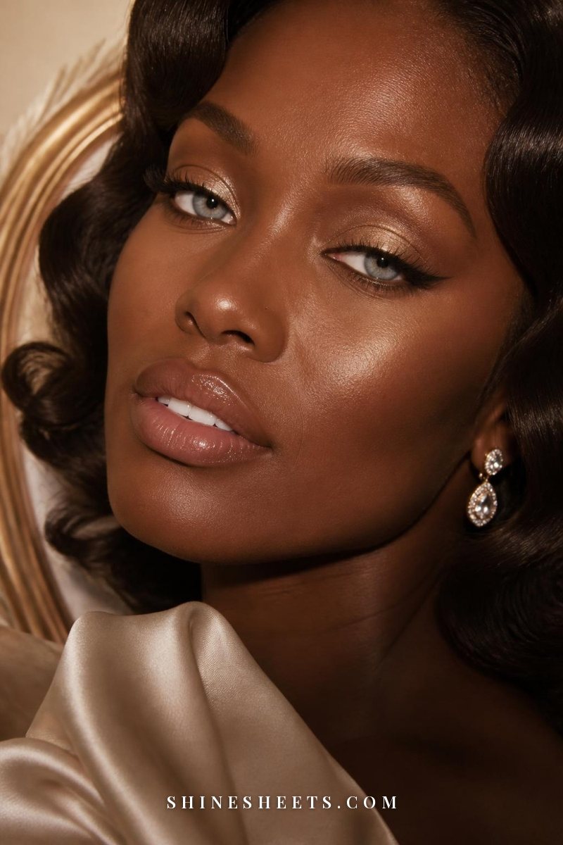 Close-up of a woman's blue eyes with shimmering champagne eyeshadow and a soft winged liner