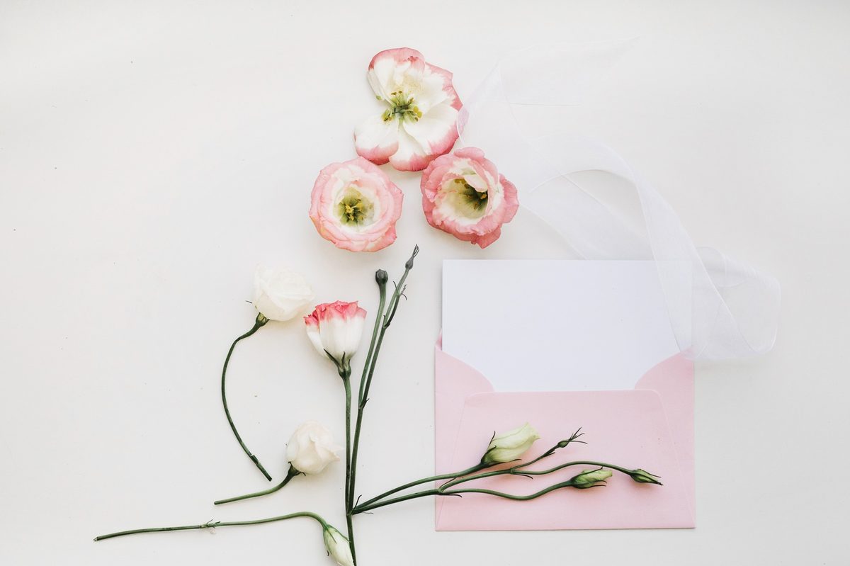 Pink envelope with blush flowers on a white background