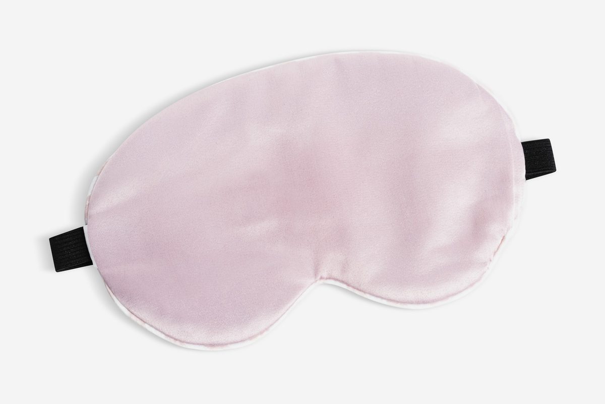 Pink silk sleep mask on a white background