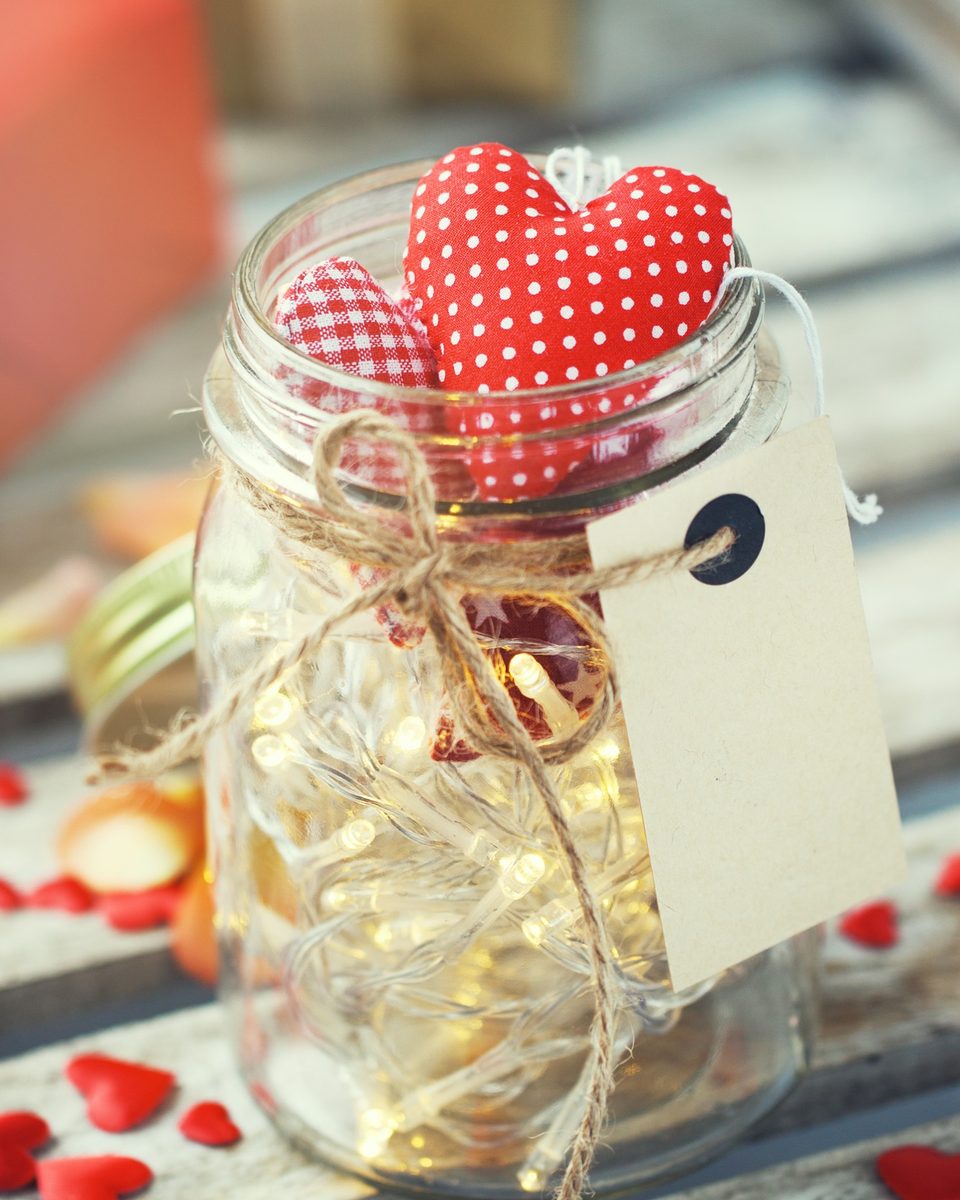 Glass jar with fairy lights and a red heart tied with a tag